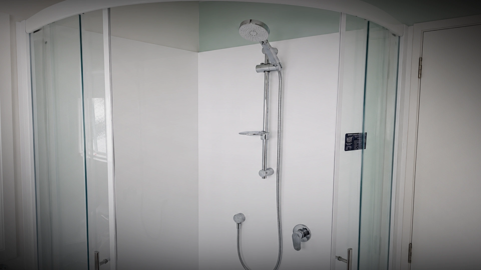 Plumber repairing a shower mixer and rail in a Napier bathroom